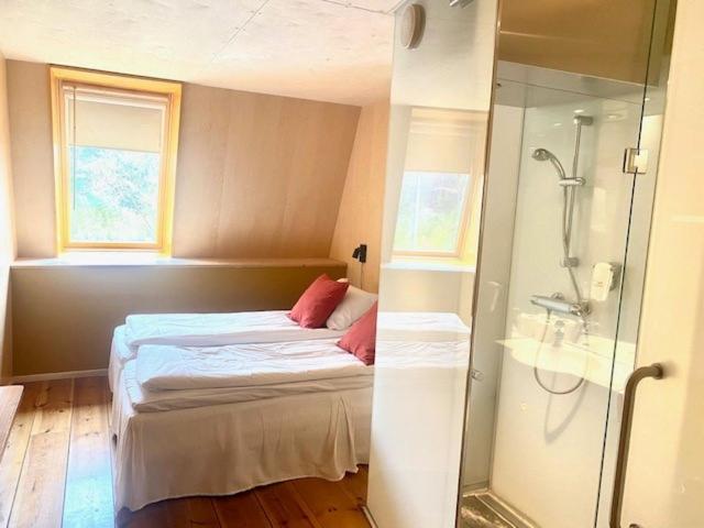 Dormitorio pequeño con cama y ducha en Preikestolen BaseCamp en Jørpeland