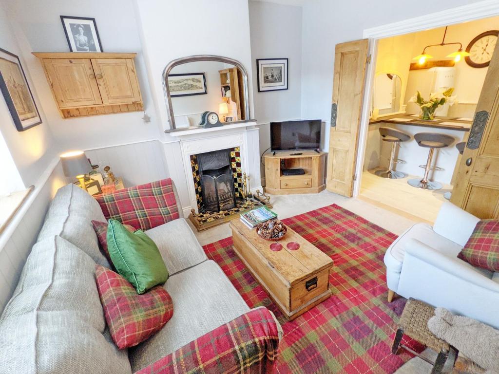 a living room with a couch and a fireplace at Sparrow Cottage - Westbourne in Westbourne