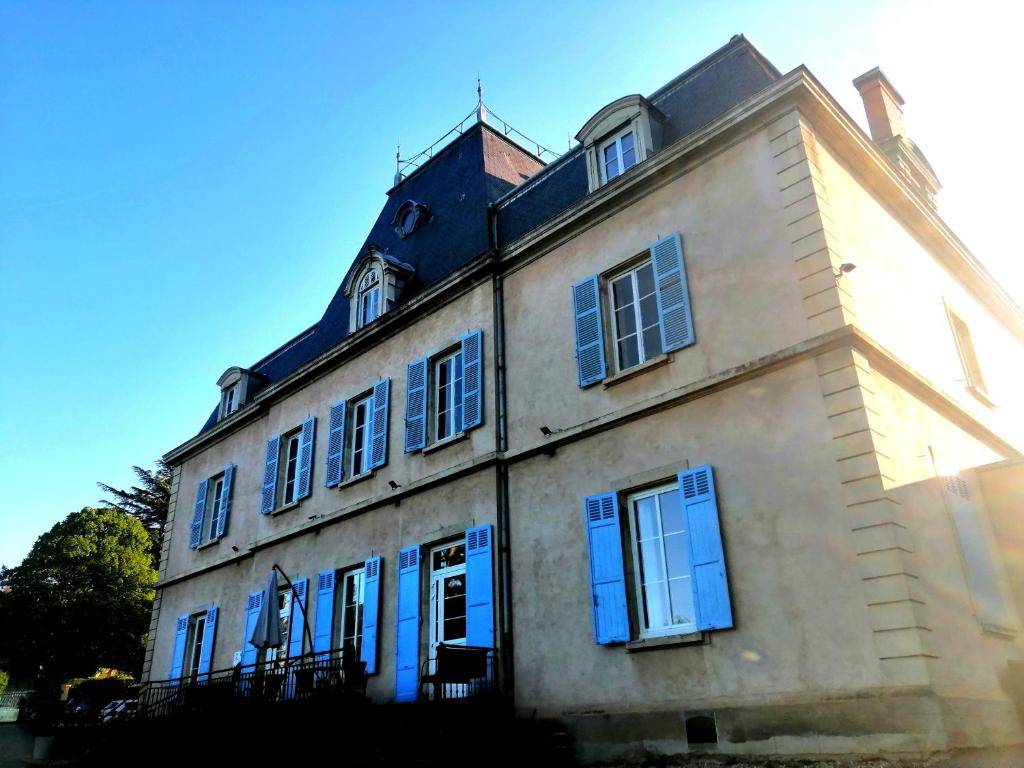 un edificio antiguo con puertas y ventanas azules en VTF Le Domaine Les Hautannes, en Saint-Germain-au-Mont-dʼOr