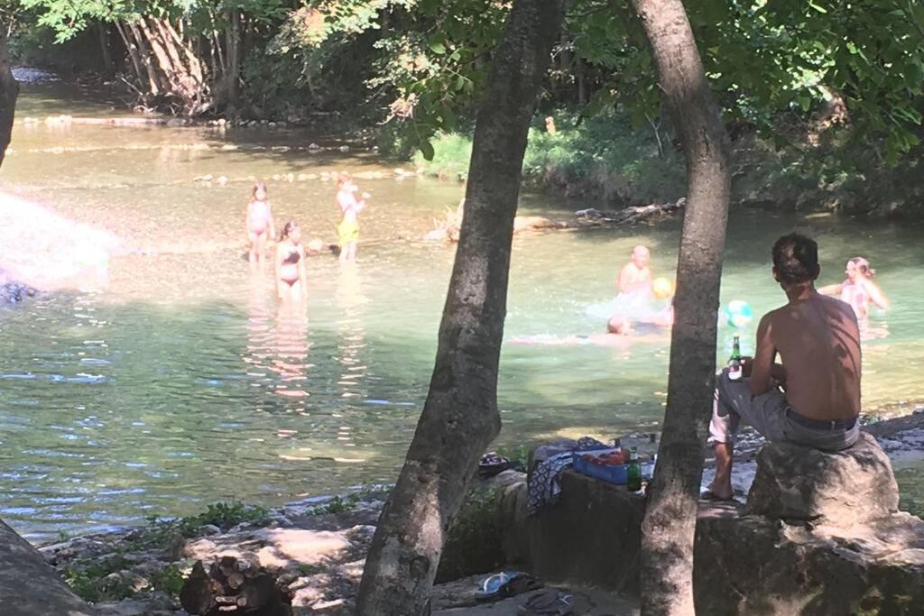 een groep mensen die in een rivier zwemmen bij Le gîte de la vallée du Douctouyre in Dun