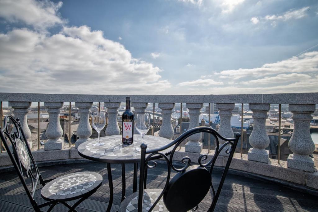 Una botella de vino sentada en una mesa en un balcón en Victoria Court Suites - Aberdeen en Aberdeen