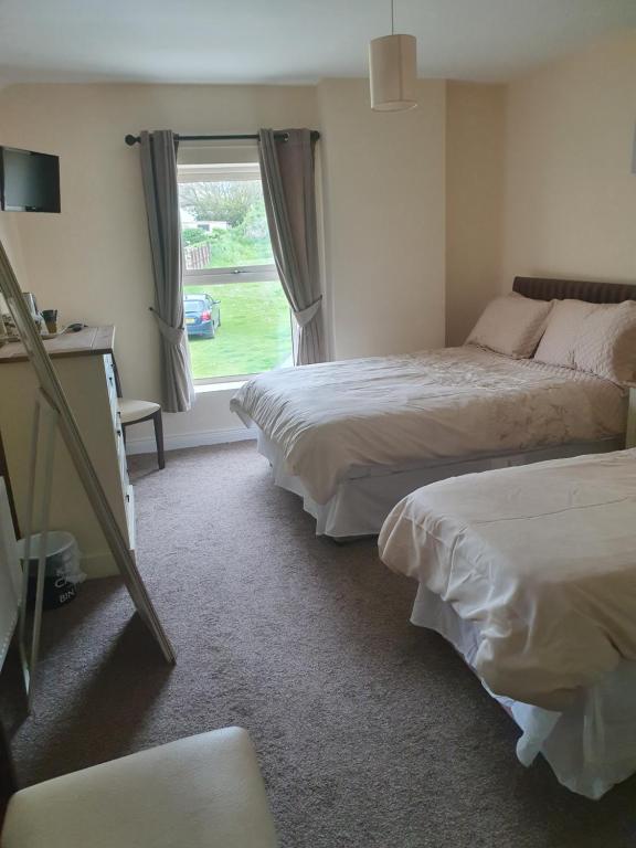 a hotel room with two beds and a window at Willards B&B in Bundoran