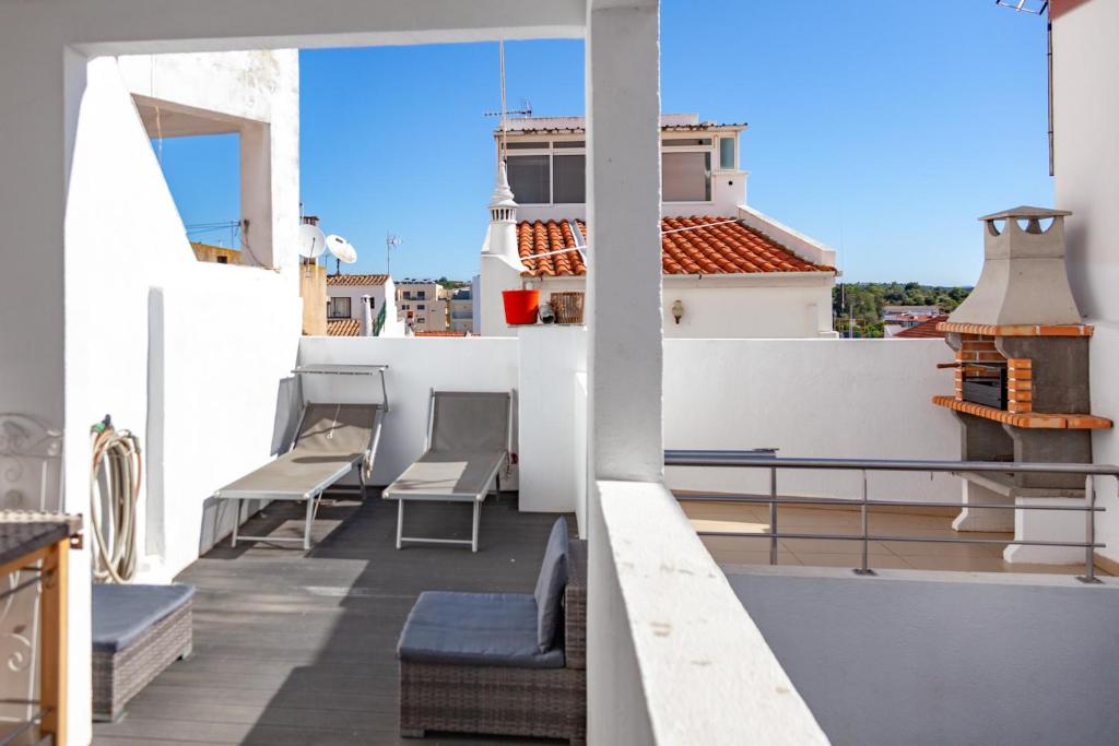 a balcony with chairs and a view of a building at Casa Monika II - Portimão in Portimão