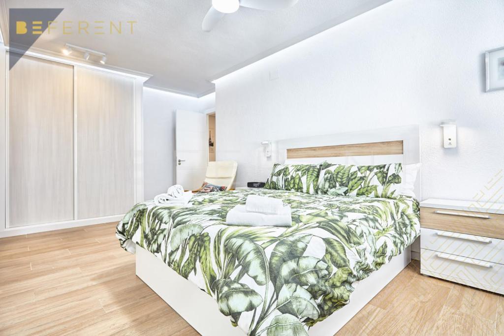 a bedroom with a bed with a green leafy bedspread at Beferent San Juan Pueblo II in San Juan de Alicante