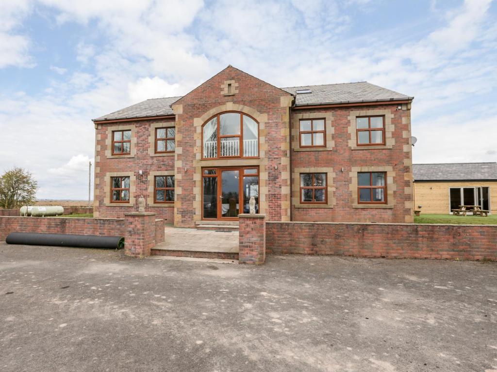 a large brick house with a lot of windows at West Border Farm in Wigton