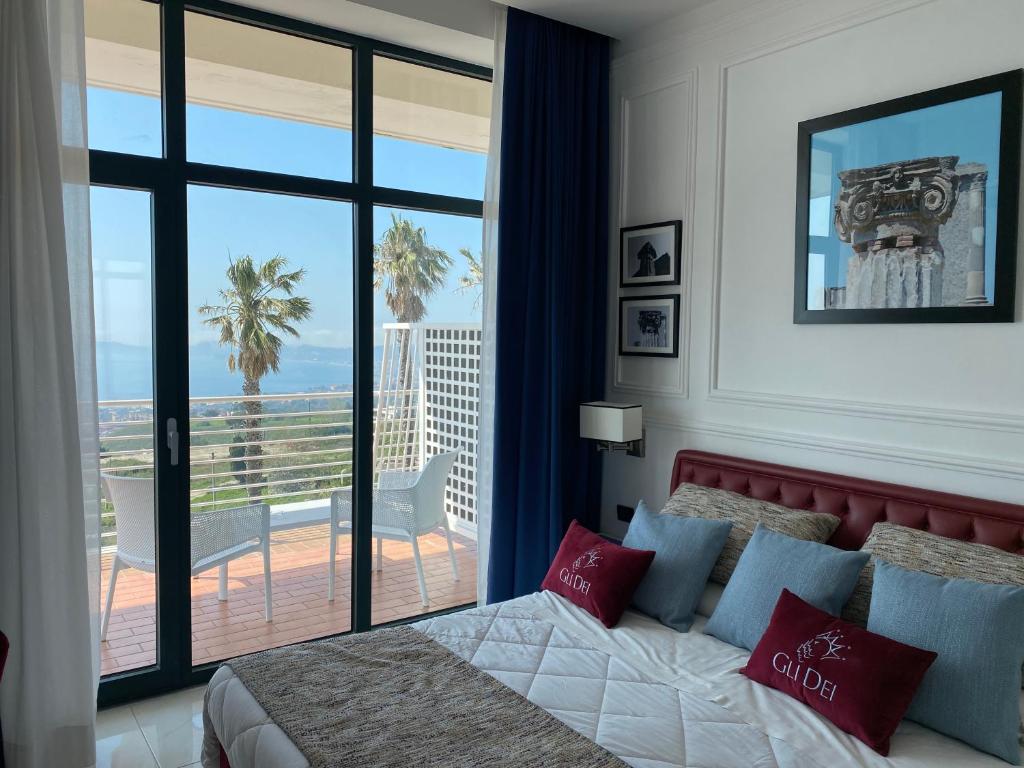 a bedroom with a bed and a view of the ocean at Gli Dei in Pozzuoli