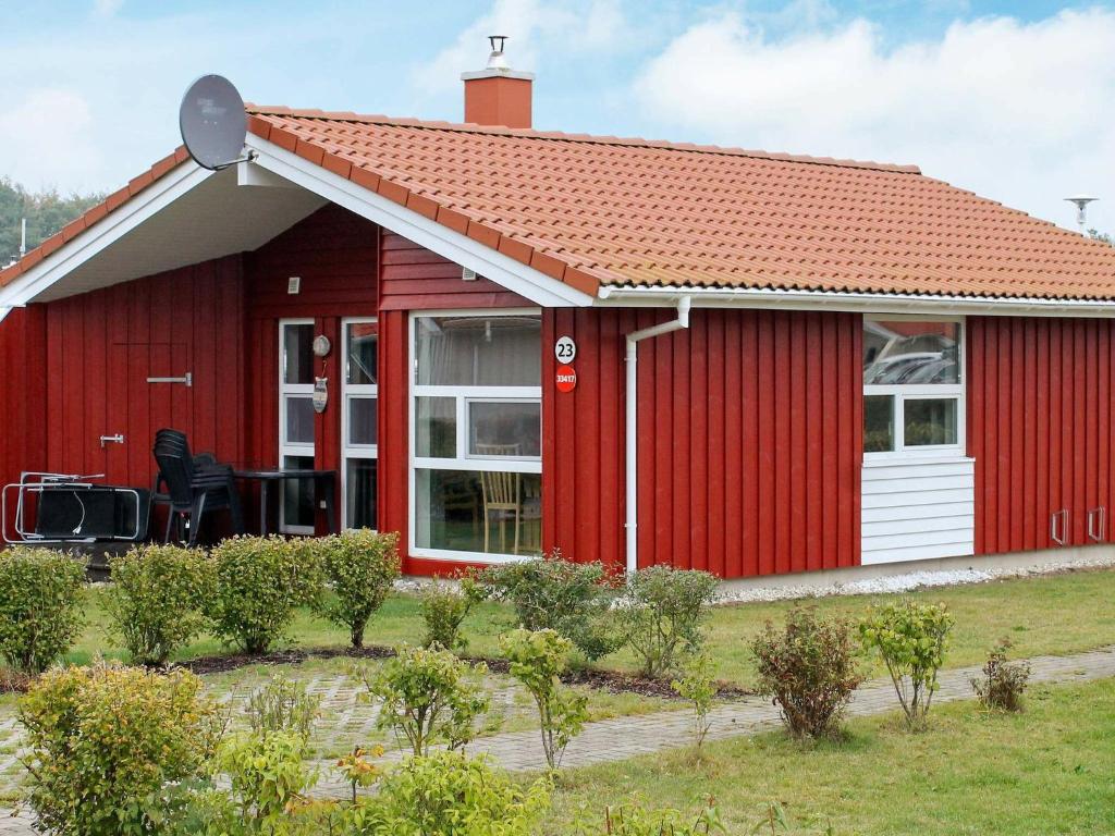 a red cottage with a red roof at Two-Bedroom Holiday home in Grömitz 1 in Grömitz