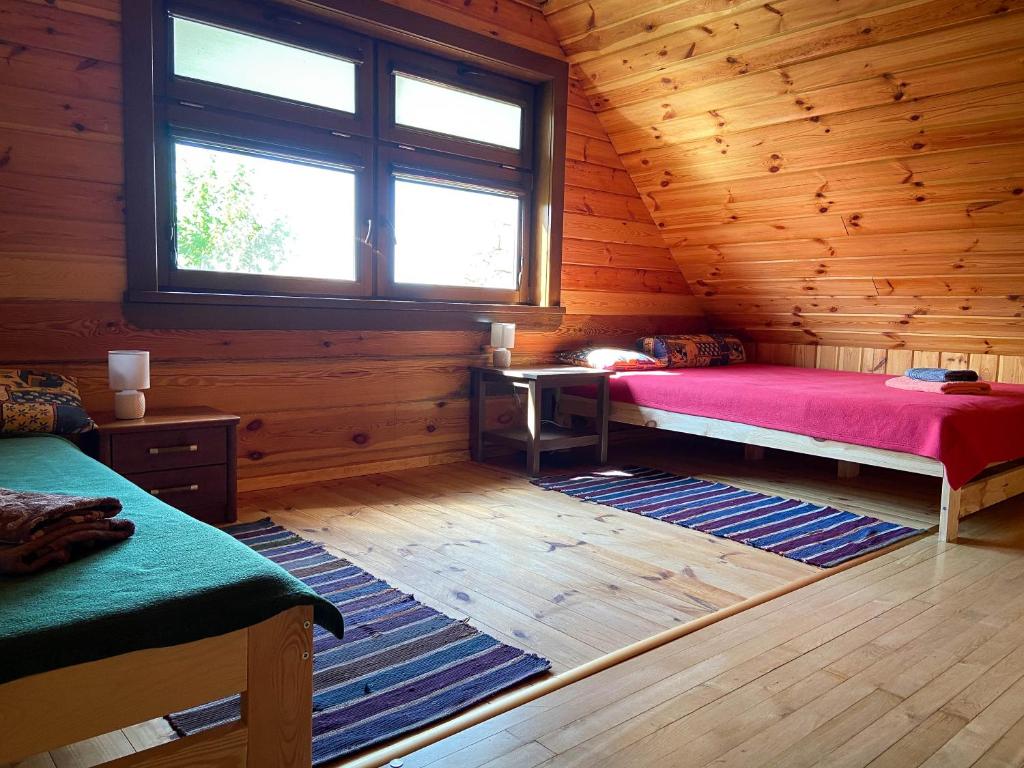 Sosnowy domek w rezerwacie nad Narwią في Bokiny: غرفة بسريرين في كابينة خشبية