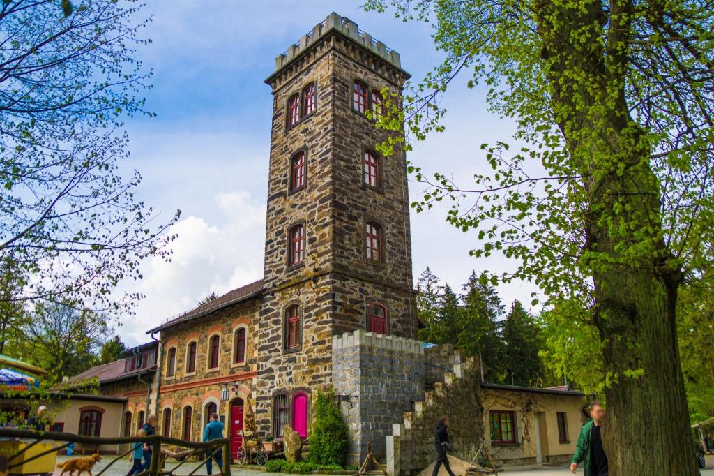 un edificio de piedra alto con una torre de reloj en Berggasthof Butterberg, en Bischofswerda