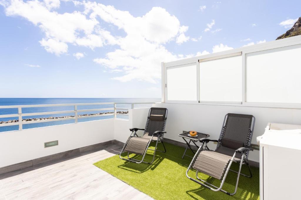 2 sillas en un balcón con vistas al océano en Home2Book Sea Front Las Teresitas Beach Attic, en San Andrés