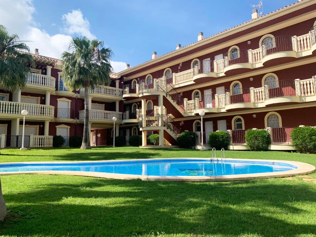 um grande edifício com uma piscina em frente em Apartamentos Madeira 3000 em Alcossebre