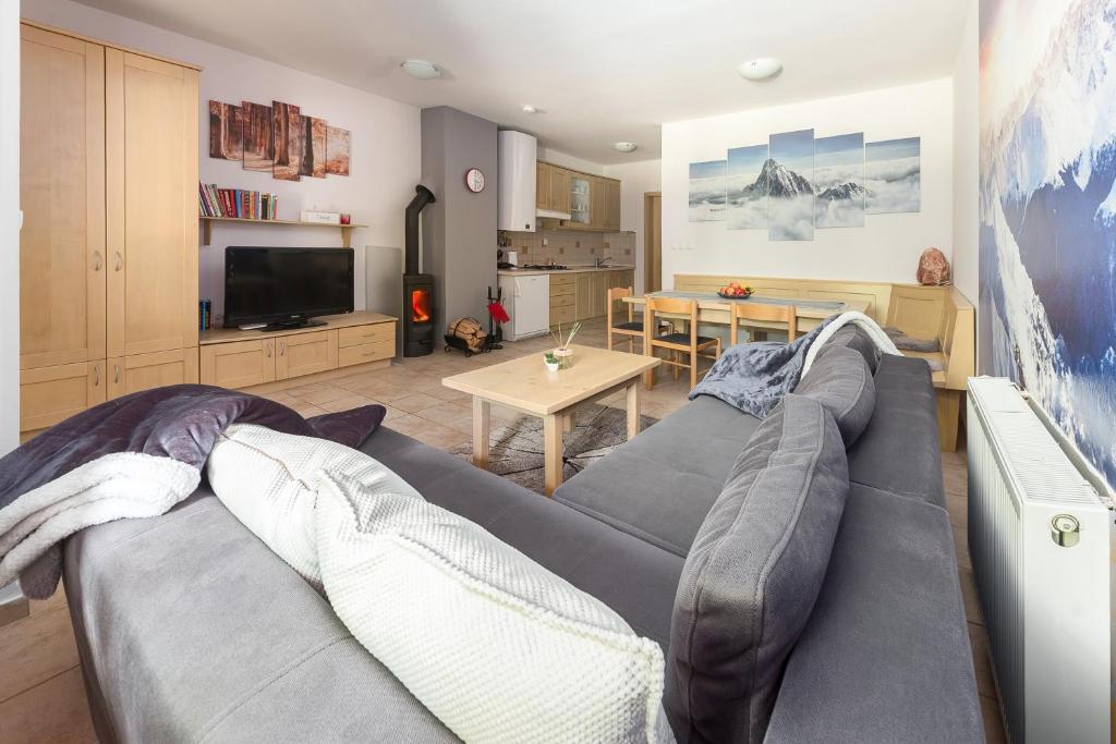 a living room with a gray couch and a table at Peaceful Rogla Apartment in Zreče