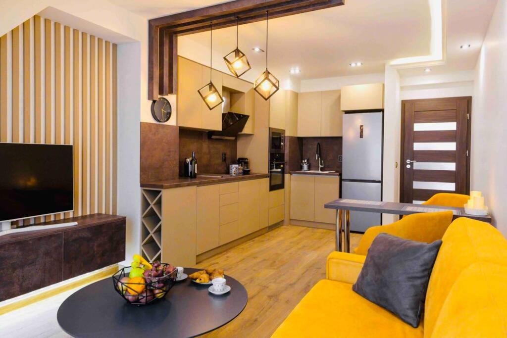 a living room with a yellow couch and a kitchen at COZY,STYLISH,MODERN APT WITH TERRACE/TOP LOCATION in Sofia
