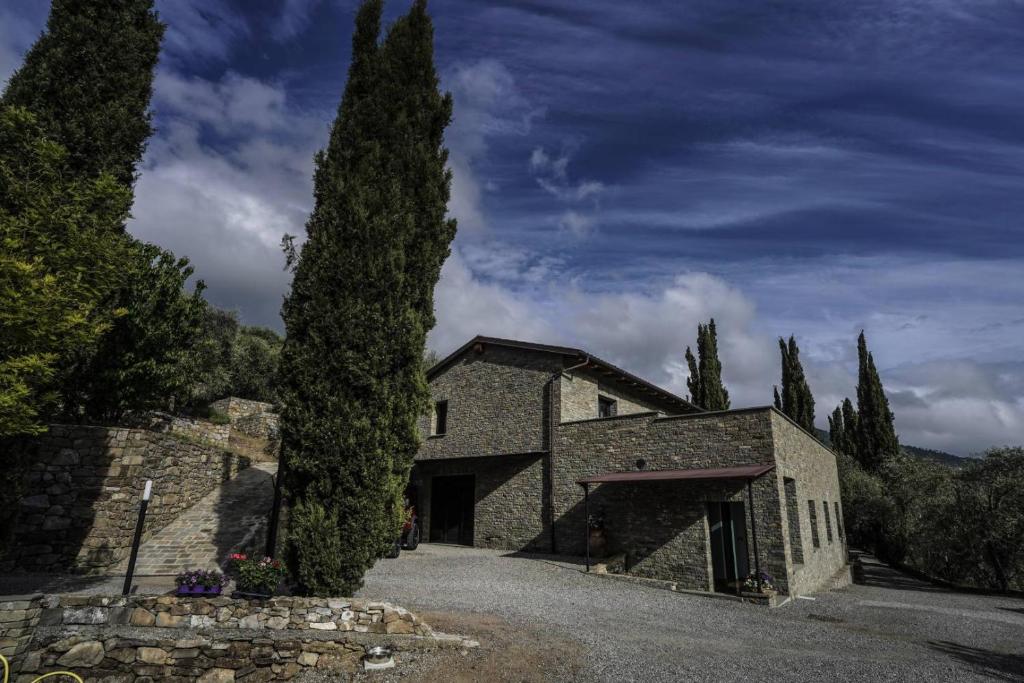 - un grand bâtiment en pierre avec un arbre en face dans l'établissement B&B il Pianolo, à Perinaldo