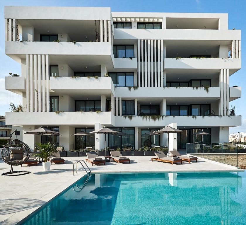 a building with a swimming pool in front of a building at Downtown Park in Paphos City