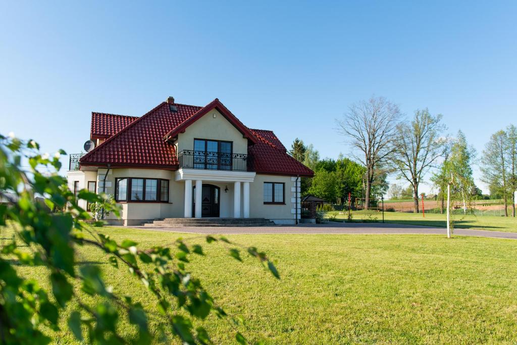 une maison blanche avec un toit rouge dans l'établissement Perła Rospudy, à Filipów