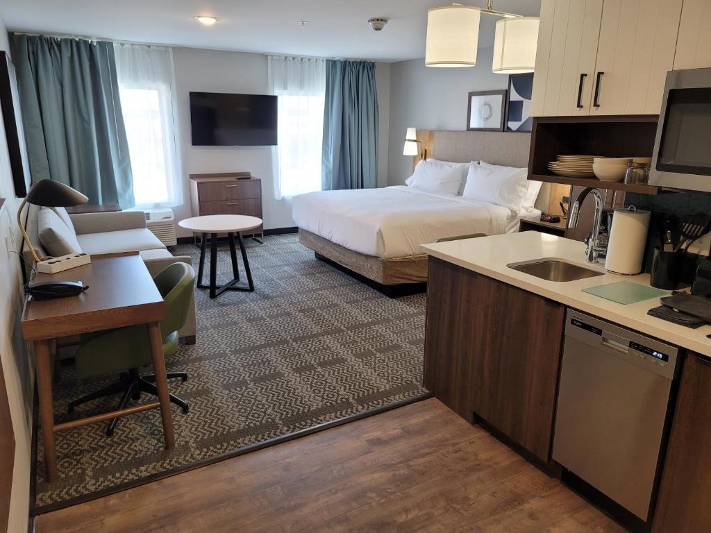 路易維爾的住宿－Staybridge Suites - Louisville - Expo Center, an IHG Hotel，酒店客房配有一张床、一张书桌和一间厨房。