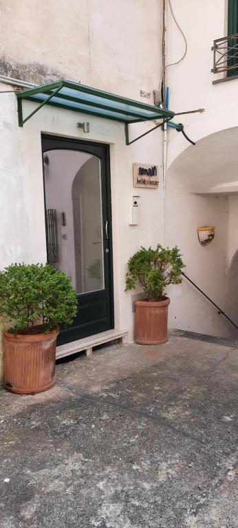 two potted plants sitting in front of a door at Amalfi Holiday House Rooms & Apartments in Amalfi