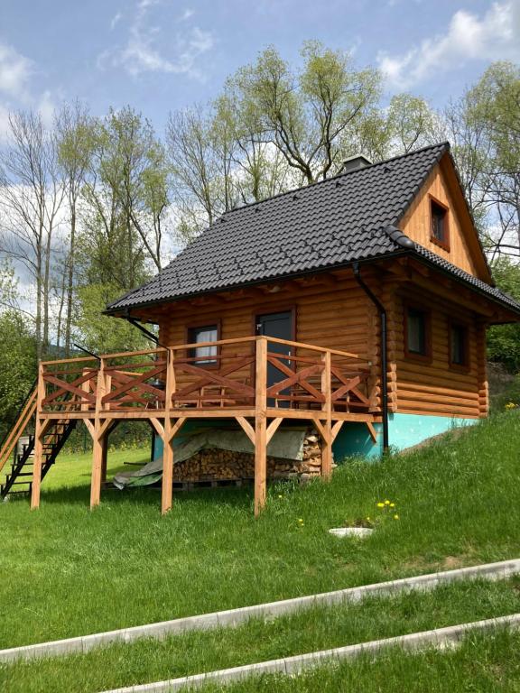 a log cabin with a large deck in the grass at Drevenica Magdaléna in Trstené