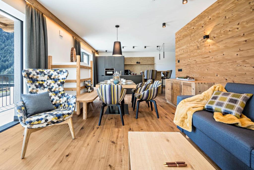 a living room with a blue couch and a table and chairs at App Mulin Rudl mit Sauna in Mühlbach
