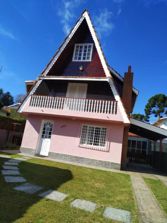 una casa rosa con techo rojo en Casa Campos do Jordão, en Campos do Jordão