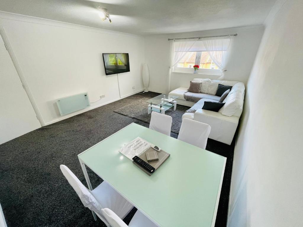 a living room with a white table and a couch at Modern 2 bed Apartment Near City Centre in Glasgow