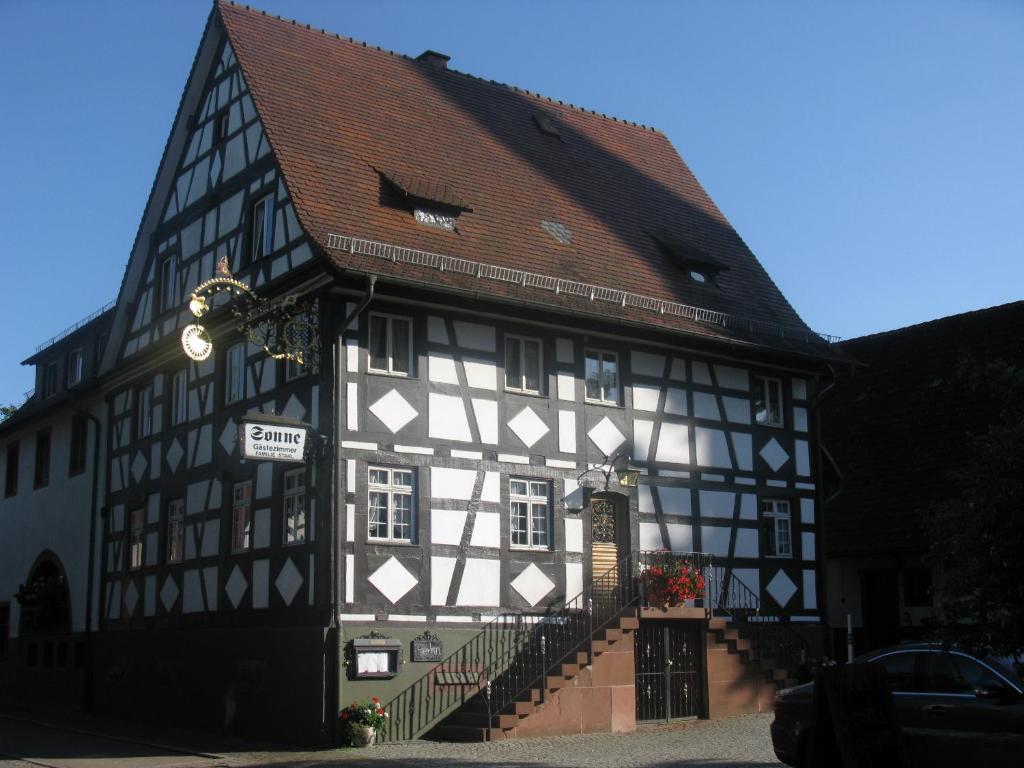 an old black and white building with a sign on it at Gasthaus Sonne in Vörstetten