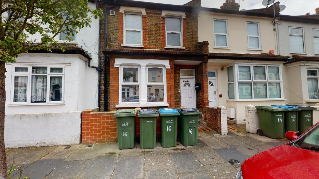 a house with four trash cans in front of it at The Rock Apartments II in London