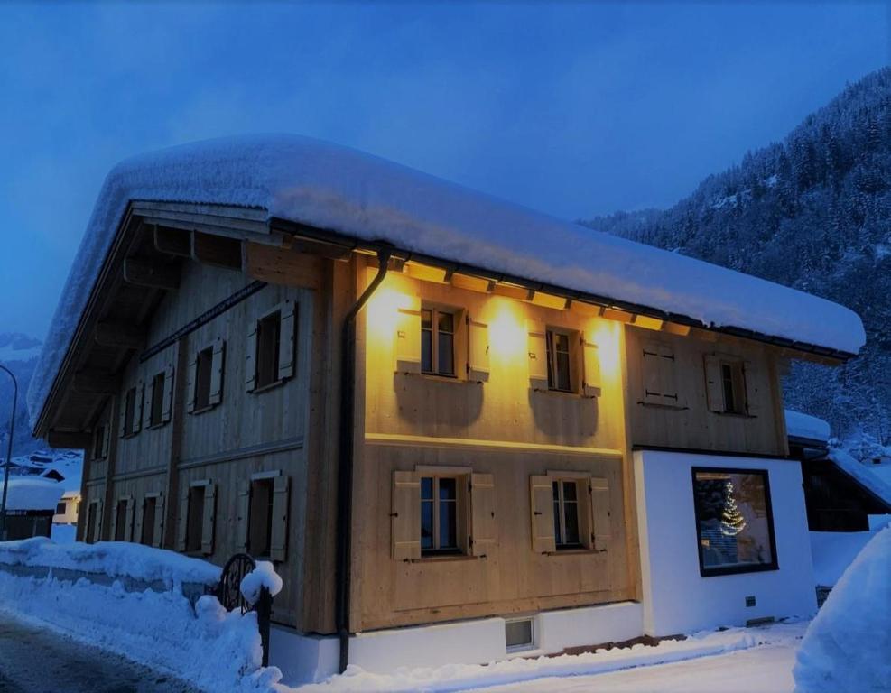 een gebouw bedekt met sneeuw met lichten erop bij Chalet 14 in Sankt Gallenkirch