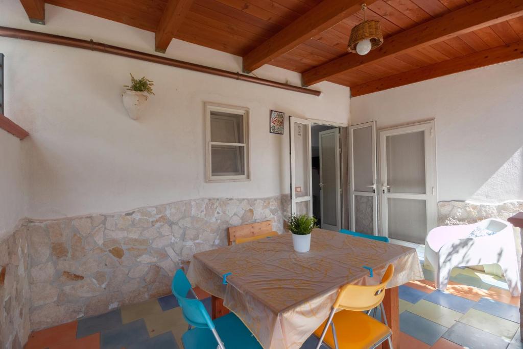 a table and chairs in a room with a stone wall at B&B Tor Di Lupo in Mattinata