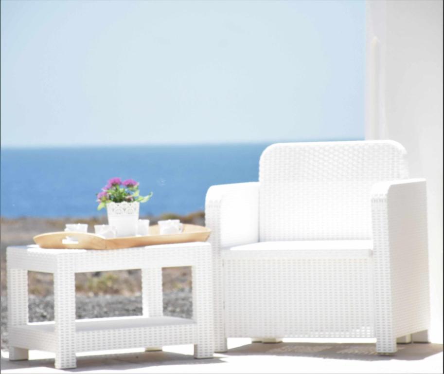 una silla blanca de mimbre, una mesa, una silla, una mesa y una silla en Villa Verde Mar, en Tinajo