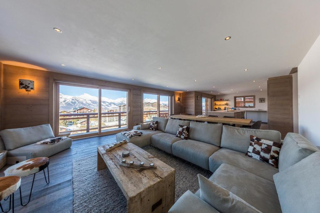 a living room with a couch and a table at Le Refuge 2 - Spa access - Close to ski lift in Nendaz