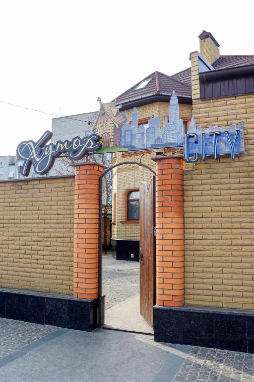 ein Backsteingebäude mit einem Schild darüber in der Unterkunft Хутор-city in Korostyshiv