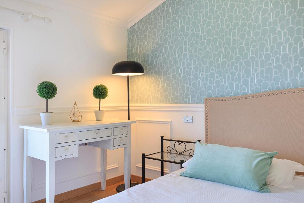 1 Schlafzimmer mit einem Schreibtisch, einem Bett, einem Schreibtisch und einem 6-dx-Bett in der Unterkunft Pandora Stresa - By Impero House in Stresa