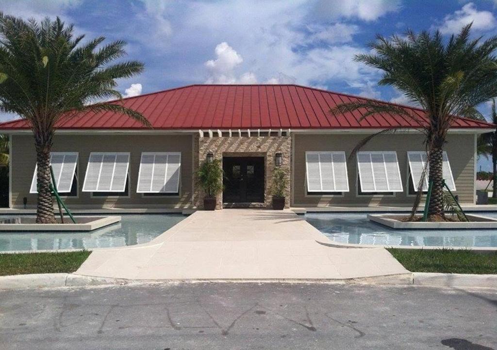 una casa con techo rojo y dos palmeras en Luxury Venetian Condo, en Nassau