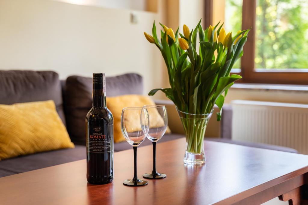 Una botella de vino y dos copas en una mesa. en Karkonosky Apartamenty - Szosa Czeska I, en Szklarska Poręba
