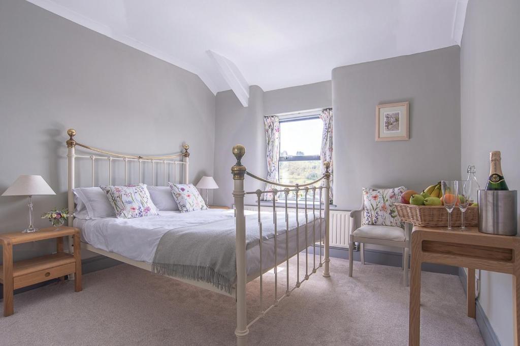 a bedroom with a bed and a chair and a window at Dartmoor Inn in Princetown