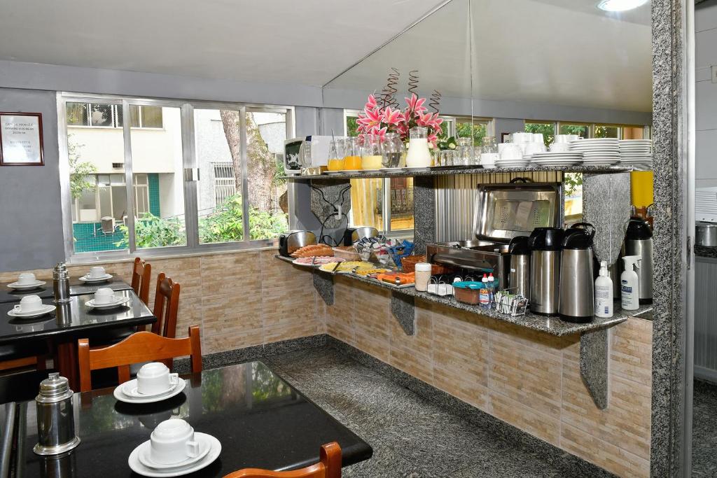 a kitchen with a counter and tables in a restaurant at Hotel Rio Claro in Rio de Janeiro