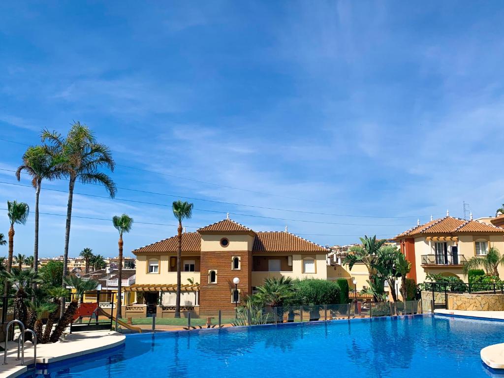 uma grande piscina em frente a uma casa em Apartamento Narváez- Altos Del Tomillar em Torre del Mar