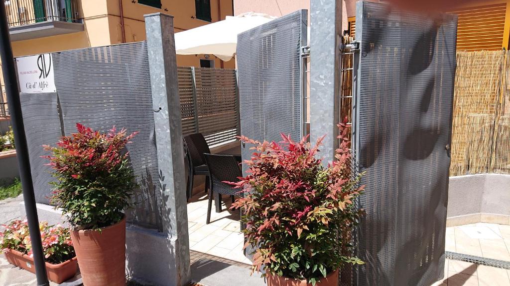 une porte ouverte avec des plantes en pot sur un patio dans l'établissement Cà d'Alfré, à La Spezia