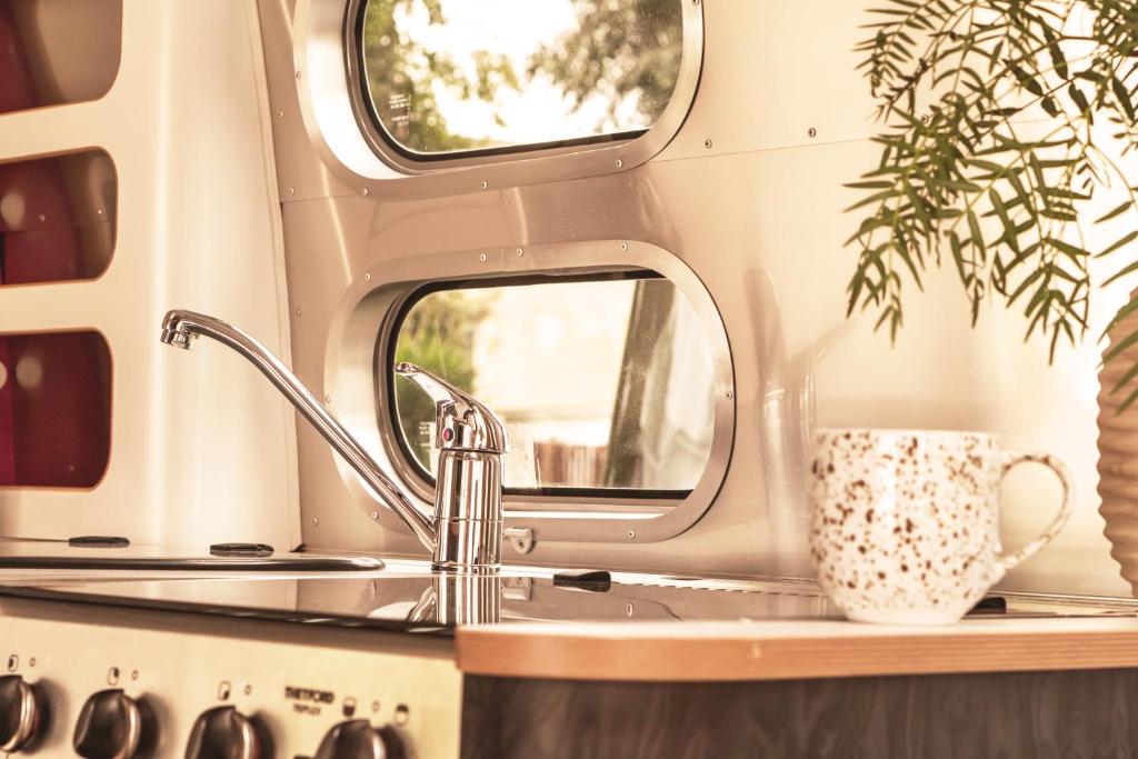 a sink in a trailer with two mirrors at Procida Camp & Resort - La Caravella in Procida