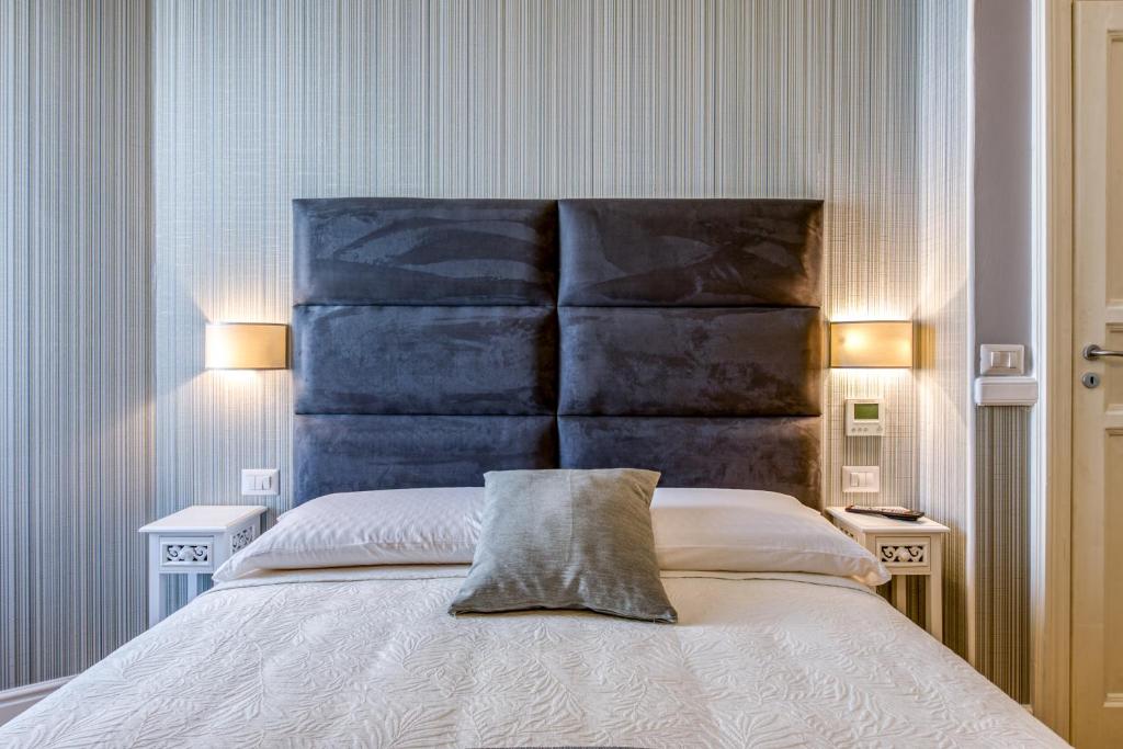 a bedroom with a large bed with a blue headboard at Rione XXII Apartments in Rome