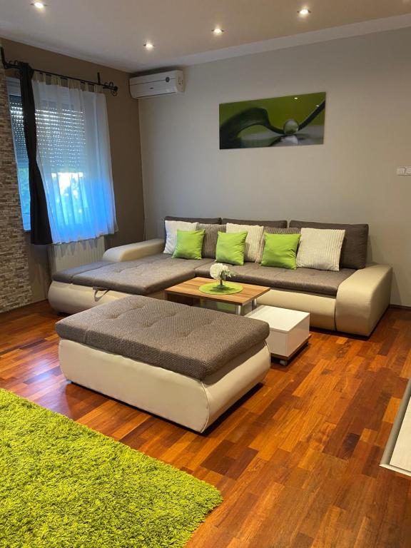 una sala de estar con 2 sofás y una alfombra verde en Németh Apartman Sárvár, en Sárvár