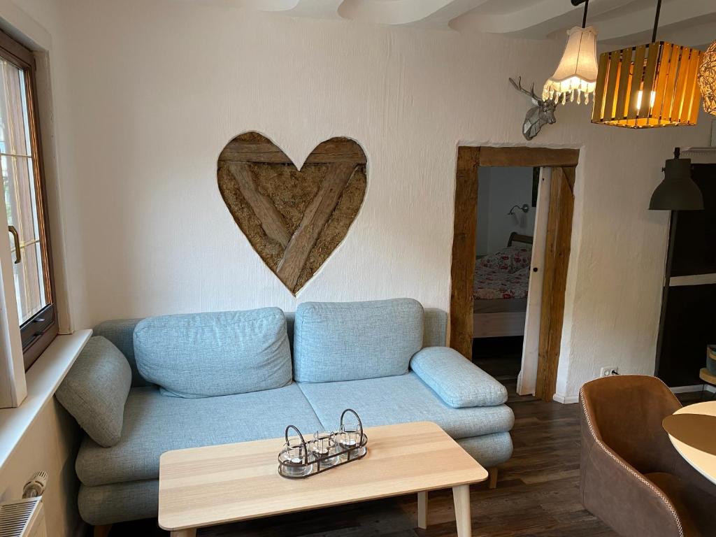 - un salon avec un canapé bleu et un cœur sur le mur dans l'établissement Schöne Ferienwohnung Burgruine Fachwerkhaus, à Bacharach
