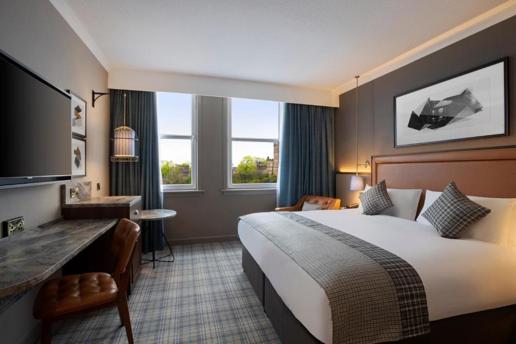 a hotel room with two beds and a television at Leonardo Royal Hotel Edinburgh - Formerly Jurys Inn in Edinburgh