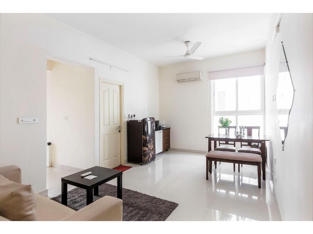 a living room with a couch and a table at BluO 1BHK Hitech City - Gym, TT, Terrace Garden, Lift in Hyderabad