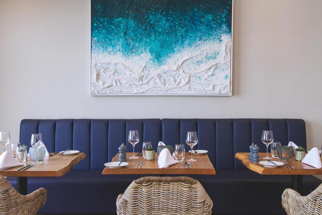 a dining room with two tables with wine glasses at Esplanade Hotel in Newquay