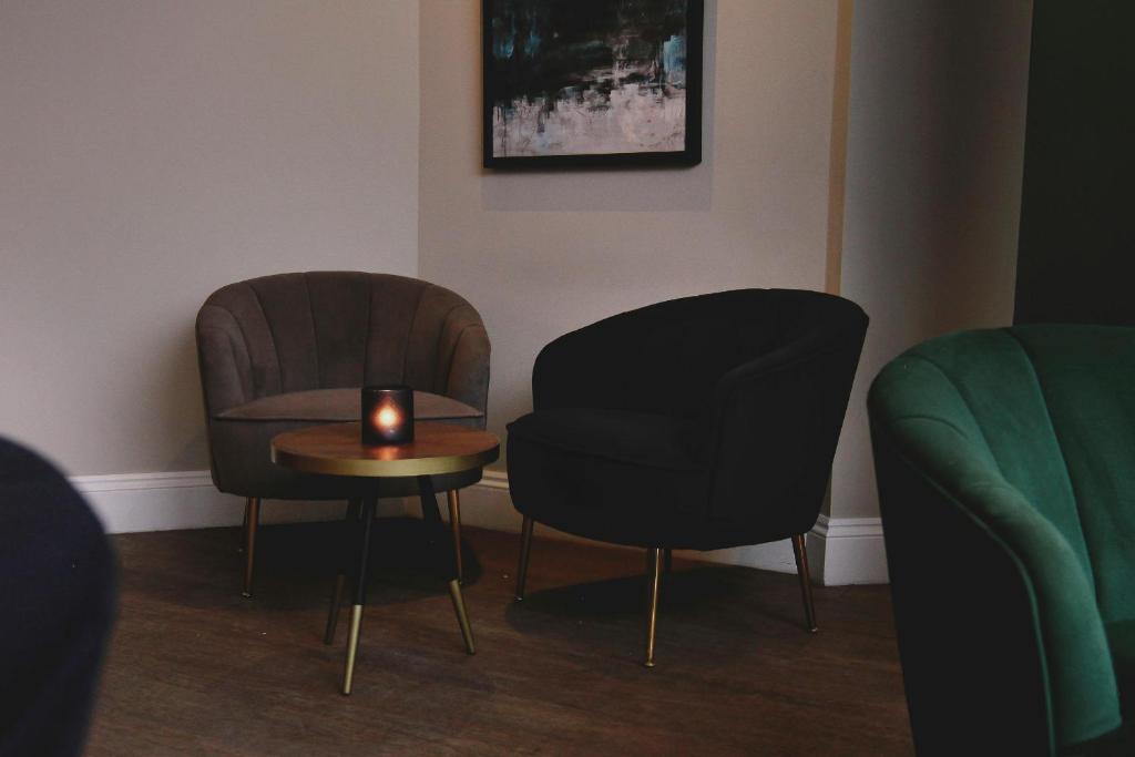 two chairs and a table with a candle on it at Esplanade Hotel in Newquay