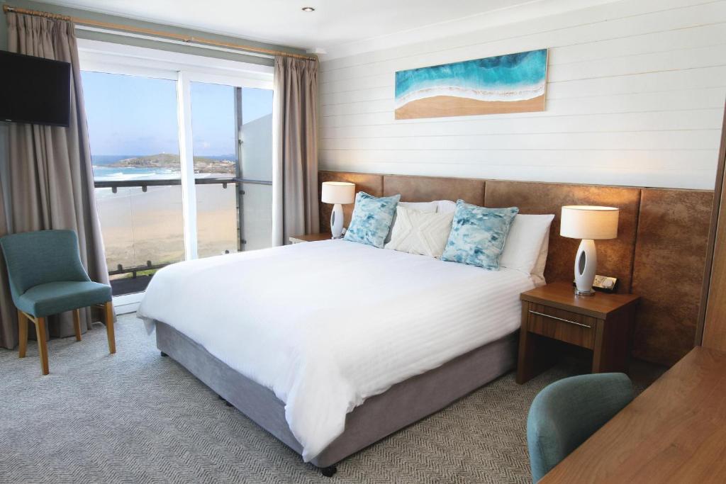 a bedroom with a bed with a view of the ocean at Esplanade Hotel in Newquay