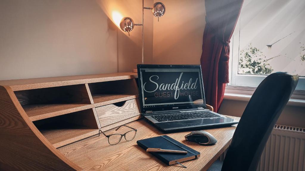 a desk with a laptop computer on top of it at Sandfield Guest House in Oxford